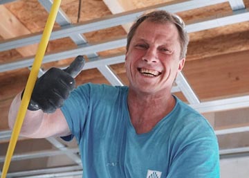 Mitarbeiter für den Innenausbau lacht während der Arbeit.