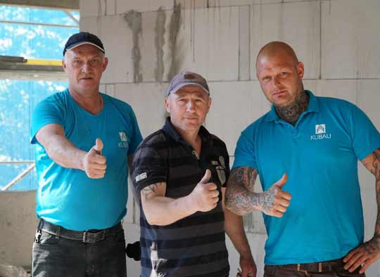 Maurerarbeiter der Kubau GmbH Drei Maurer posieren vor der Kamere mit Daumen hoch